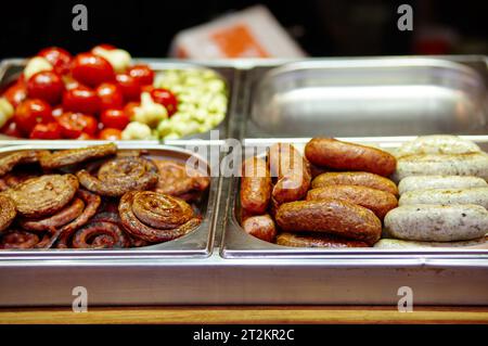 Weihnachtliches Street Food Festival auf Messe im Stadtzentrum, Winterferien. BBQ Street Food zum Verkauf, leckere Würstchen auf dem Holiday Street Market in europa Stockfoto