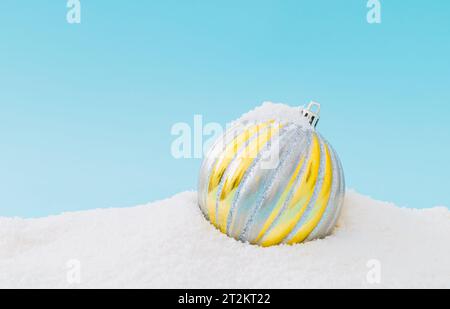 Kreative Komposition aus Weihnachtskugeldekoration auf Schnee. Minimaler Urlaubshintergrund. Schickes Weihnachts- oder Neujahrskonzept. Winter-Idee. Stockfoto