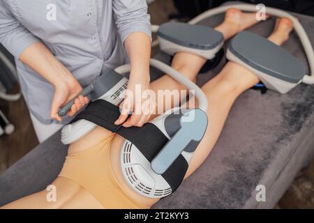 Frau, die auf dem Gesäß behandelt wird, um Fett zu verbrennen, Muskeln aufzubauen und Cellulite zu entfernen. Professioneller Schönheitssalon Stockfoto