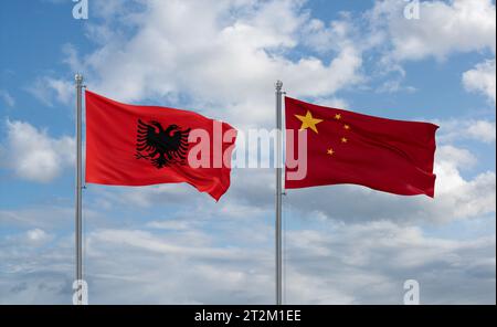 China- und Albanienflaggen schwenken zusammen auf blauem bewölktem Himmel, zwei Länder-Beziehungskonzept Stockfoto