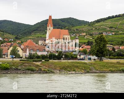 Blick über die Donau, Pfarrkirche Mariä Himmelfahrt, Weinberge im Rücken, Weissenkirchen an der Donau, Wachau, Niederösterreich Stockfoto