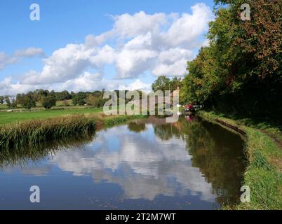 Foto am Oxford Canal in England im Herbst, das Reflexionen und ein Schmalboot zeigt. Stockfoto