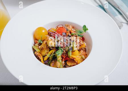 Gemüseeintopf mit Kartoffeln, Tomaten und Kräutern mit Sauce in einer tiefen Seitenansicht des Tellers Stockfoto