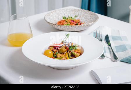 Gemüseeintopf mit Kartoffeln, Tomaten und Kräutern mit Sauce in einer tiefen Seitenansicht des Tellers Stockfoto