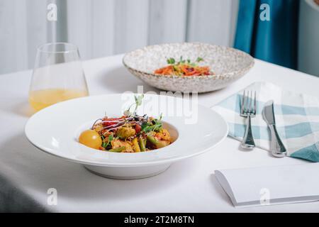 Gemüseeintopf mit Kartoffeln, Tomaten und Kräutern mit Sauce in einer tiefen Seitenansicht des Tellers Stockfoto