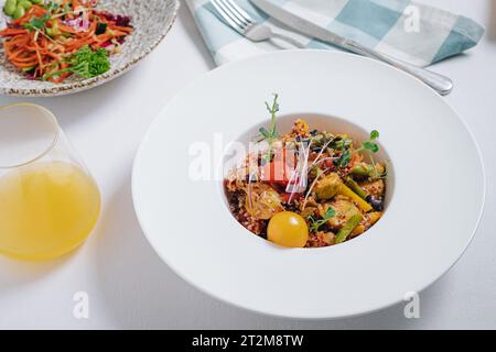 Gemüseeintopf mit Kartoffeln, Tomaten und Kräutern mit Sauce in einer tiefen Seitenansicht des Tellers Stockfoto