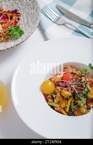 Gemüseeintopf mit Kartoffeln, Tomaten und Kräutern mit Sauce in einem tiefen Teller von oben Stockfoto