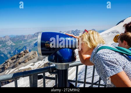 Ein Tourist blickt durch ein Beobachtungsteleskop auf dem Titlis-Gipfel, einem Berg in den URI-Alpen zwischen den Kantonen Obwalden und Bern oberhalb des Dorfes Engelberg Stockfoto