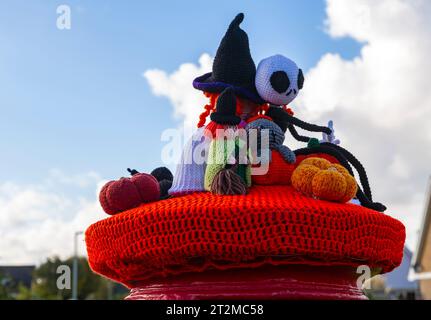 Poole, Dorset, Großbritannien. Oktober 2023. Ein gestrickter Briefkasten-Topper erscheint auf einem roten Briefkasten in Poole, Dorset mit einem Halloween-Thema mit Hexen, Geistern, Spinnen und Kürbissen. Quelle: Carolyn Jenkins/Alamy Live News Stockfoto