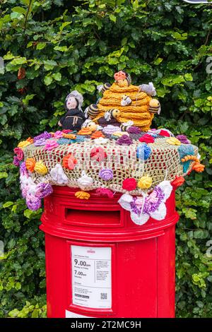 Gestrickte und gehäkelte Dekoration für eine Royal Mail Postbox in der Nähe der Gloucester Cathedral, England, Großbritannien Stockfoto