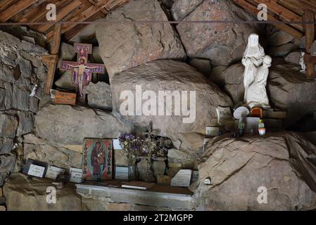 Inneneinrichtung, rustikaler Altar und Christus am Kreuz in der halbtroglodyten Kapelle Notre Dame des Monts Allos Alpes-de-Haute-Provence Frankreich Stockfoto