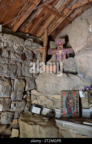 Inneneinrichtung, rustikaler Altar und Christus am Kreuz in der halbtroglodyten Kapelle Notre Dame des Monts Allos Alpes-de-Haute-Provence Frankreich Stockfoto