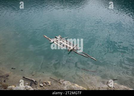 Ramshackiges Holzfloß oder provisorisches Floß Adrift oder Floating on Lake Stockfoto