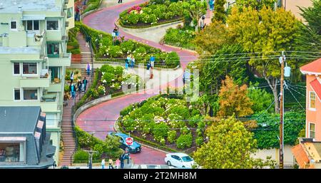 Luftmenschen und Autos, die die Lombard Street durchquerten, blickten auf die gewundene rote Backsteinstraße Stockfoto