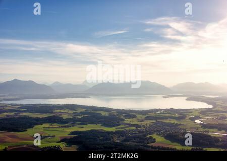 Blick über den Chiemsee auf die Alpen mit Wolken, Staub und blauem Himmel Stockfoto