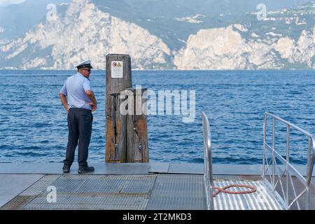 Ein Mitarbeiter des Garda Express-Transportunternehmens wartet auf die Fähre für Touristen von Limone Sul Garda nach Malcesine Stockfoto