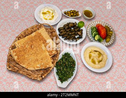 Kurdische Mahlzeit aus Pitabrot, gefüllten Traubenblättern, Salat, Gurke, Tomaten, Gurken, Oliven, Hummus, Joghurt. Stockfoto