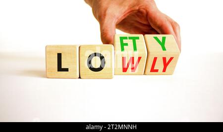 Symbol „hoch“ oder „niedrig“. Concept Words Lofty niedrig auf Holzblock. Schöner weißer Tisch mit weißem Hintergrund. Geschäftsmann Hand. Geschäftsleute hoch oder niedrig Co Stockfoto