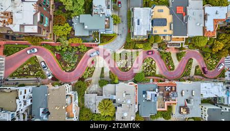 Man blickt geradeaus auf die Lombard Street und die Autos fahren die rote Backsteinstraßenantenne hinunter Stockfoto