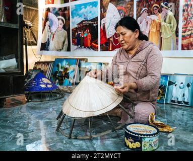 Hue, Vietnam, 18. November 2022: Eine Frau fertigt traditionelle vietnamesische konische Hüte in einem Geschäft in Hue, Vietnam Stockfoto