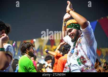 Ein Mann in traditioneller indischer Kleidung sah beim Navratri-Festival den traditionellen Garba-Tanz tanzen. Das Hindu Navratri Festival, das 9 Nächte dauert, wird jedes Jahr im Oktober in ganz Nordindien, insbesondere im Bundesstaat Gujarat, gefeiert, um die Göttin Durga zu ehren und den Sieg des Guten über das Böse zu feiern. Die Menschen versammeln sich auf offenem Gelände, um gemeinsam den traditionellen Garba-Tanz in traditionellen indischen Kurta- und Sari-Kleidern aufzuführen. Stockfoto