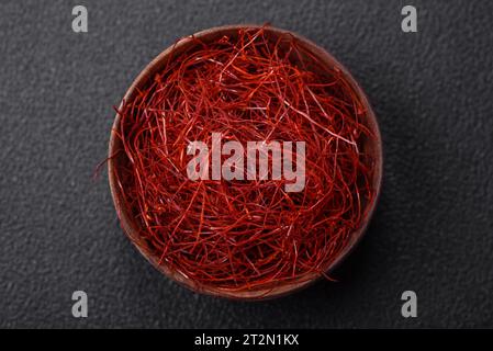 Rote, dünne, heiße Chilifäden auf dunklem Hintergrund. Zum Dekorieren asiatischer Gerichte Stockfoto