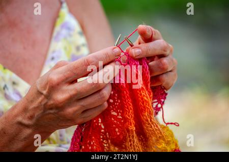 Eine Frau strickt einen Schal aus Naturgarn Stockfoto