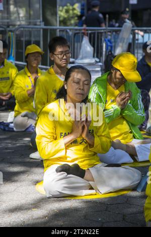 Mitglieder der spirituellen Gruppe Falun Gong sitzen den Vereinten Nationen gegenüber, um darauf aufmerksam zu machen, dass sie in China viele Jahre von der nationalen Regierung verfolgt werden. Stockfoto