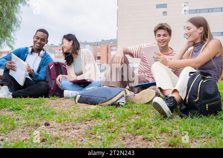 Multirassische Gruppe von Studenten, die zusammen auf dem Campus sitzen Stockfoto
