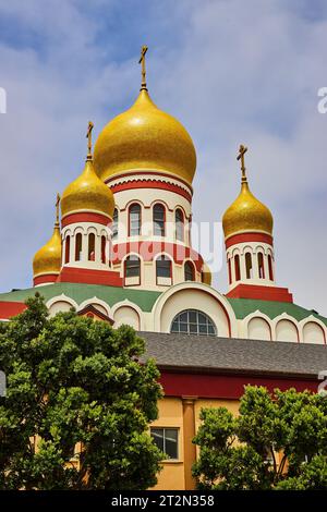 Bewölkter blauer Himmel über der Heiligen Jungfrau Kathedrale mit Bäumen unter dem Gebäude Stockfoto