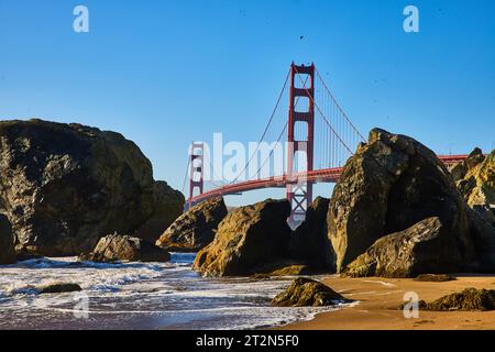 Massive Felsbrocken am Sandstrand mit Wellen und Meeresboden entlang der Küste bis zur Golden Gate Bridge Stockfoto