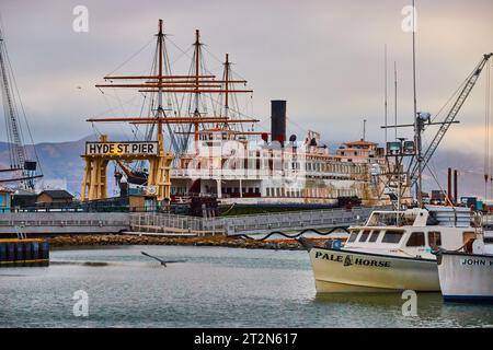 Pale Horse und John W Schiffe am Hyde St Pier mit Möwe über Wasser und Eureka dockte dahinter an Stockfoto