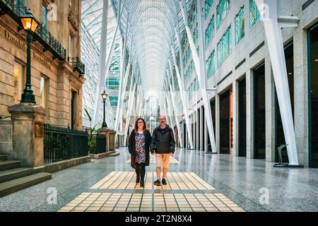 Erwachsene Paare spazieren im Brookfield Place in der Innenstadt von Toronto, Ontario, Kanada. Stockfoto