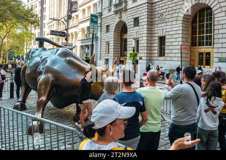 Die Leute bleiben in der Schlange, um Fotos von der Charging Bull Statue in New York, USA, zu machen. Stockfoto