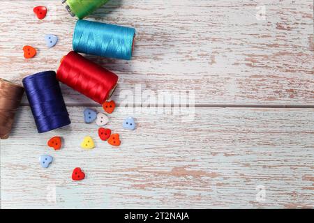 Ein Satz farbiger Garne zum Nähen von Kleidung, auf hölzernem Hintergrund Stockfoto