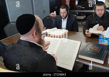 Ein Rabbiner unterrichtet eine kleine Klasse in jüdischem Recht, genannt Shulchan Aruch. In einem Tempel im Rockland County, New York. Stockfoto