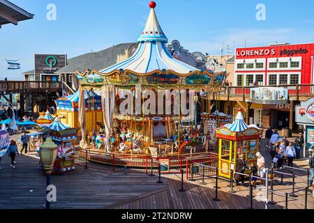 Tierkarussell am Pier 39, in dem die Leute anstehen, um in der Nähe von Restaurants zu fahren Stockfoto