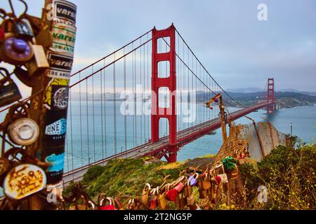 Golden Gate Bridge bei Sonnenuntergang mit einem Zaun, der mit Vorhängeschlössern bedeckt ist Stockfoto