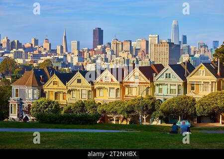 Paare genießen Sonnenuntergangsbeleuchtung auf den Painted Ladies und Downtown San Francisco Stockfoto