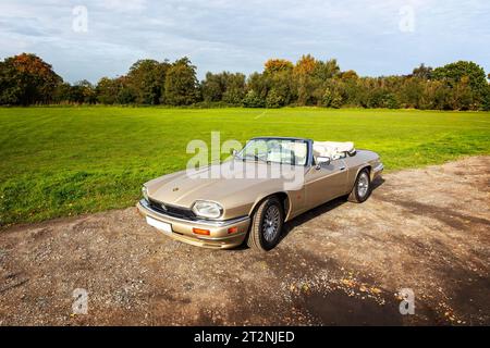 Cabriolet Jaguar XJS mit Verdeck auf einem Schotterparkplatz auf dem Land Stockfoto