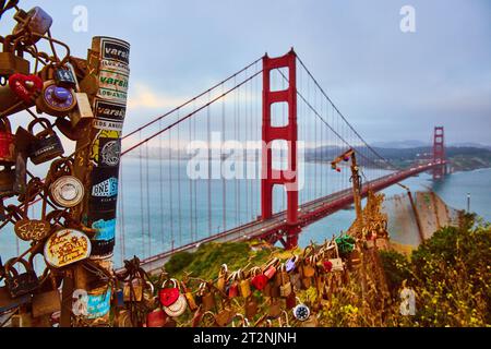 Vorhängeschlösser mit Wünschen und Träumen entlang des Zauns mit Blick auf Golden Gate Bride und die trübe Bucht bei Sonnenuntergang Stockfoto