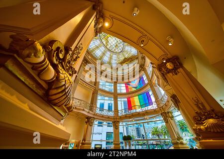 Elegante goldene Säule in der Rotunde mit Deckenblick und Fenster mit äußerer Regenbogenfahne Stockfoto