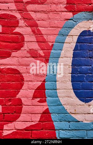 Abstrakter Hintergrund, gemalte Backsteinwand mit roten Blumen und kreisförmigen Blau- und Weißtönen Stockfoto