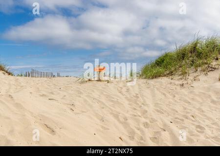 Ein kleines orangefarbenes Schild in den Dünen am Copers Beach Stockfoto