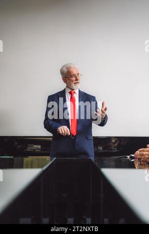 Leitender Geschäftsmann, der während der Besprechung im Konferenzraum spricht. Stockfoto