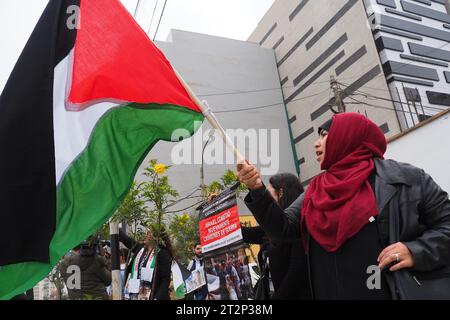 Lima, Peru. Oktober 2023. Islamische Frau, die eine palästinensische Flagge schwenkt, als sich eine Gruppe von Demonstranten vor der Botschaft der Vereinigten Staaten von Amerika in Lima versammelte, um das palästinensische Volk zu unterstützen und gegen den Israel-Hamas-Krieg im Gazastreifen vorzugehen. Quelle: Fotoholica Presseagentur/Alamy Live News Stockfoto