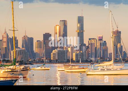 Fernsicht auf Yachten in einer ruhigen Bucht vor einer Skyline der Stadt bei Sonnenschein am späten Nachmittag in Melbourne, Victoria, Australien Stockfoto