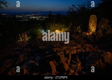 Mount Podbrdo in Medjugorje bei Nacht. Die Menschen steigen auf und beten den Rosenkranz. Die Skulptur: Viertes freudiges Geheimnis – die Darstellung Jesu. Stockfoto