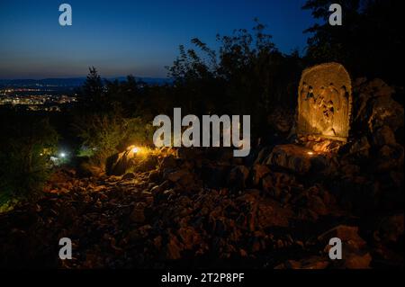 Mount Podbrdo in Medjugorje bei Nacht. Die Menschen steigen auf und beten den Rosenkranz. Die Skulptur: Viertes freudiges Geheimnis – die Darstellung Jesu. Stockfoto