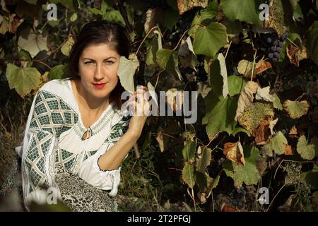 Porträt einer Frau mit Herbsttrauben im Weinberg Stockfoto